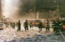 New York City firefighters and other emergency personnel survey the World Trade Center collapse area near Vessey and Greenwich Streets after the World Trade Center collapse September 11, 2001. In the worst attack on American soil since Pearl Harbor, three hijacked planes slammed into the Pentagon and New York's landmark World Trade Center on Tuesday, demolishing the two 110-story towers that symbolize U.S. financial might. REUTERS/Anthony Correia