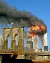 The World Trade center tower burns behind of the Brooklyn Bridge September 11, 2001 in New York. In the worst attack on American soil since Pearl Harbor, three hijacked planes slammed into the Pentagon and New York's landmark World Trade Center on Tuesday, demolishing the two 110-story towers that symbolize U.S. financial might.  REUTERS/Chris Kosachuk