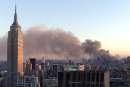 As the sun sets in Manhattan, New York City, smoke continues to pour out of the sight of the World Trade Center in New York on September 11, 2001. Both towers of the World Trade Center were hit by terrorist planes earlier in the day. The view is from midtown looking south. The Empire State Building is at left.      REUTERS/Brad Rickerby