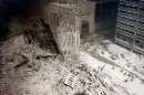 A group of firefighters walk amid rubble near the base of the destroyed South World Trade Center in New York on September 11, 2001.  In the worst terror attack on the U.S. mainland in modern history, two hijacked planes slammed into the twin towers of the World Trade Center in New York -- where about 40,000 people work -- and a third plane hit the Pentagon, across the Potomac river from Washington.    REUTERS/Peter Morgan