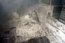 A group of firefighters walk amid rubble near the base of the destroyed South World Trade Center in New York on September 11, 2001. In the worst terror attack on the U.S. mainland in modern history, two hijacked planes slammed into the twin towers of the World Trade Center in New York -- where about 40,000 people work -- and a third plane hit the Pentagon, across the Potomac river from Washington.  REUTERS/Peter Morgan