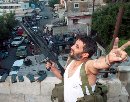 A Palestinian fires his rifle in celebration at Ain al-Hilweh refugee camp near the port city Sidon in south Lebanon, September 11, 2001.  Arab leaders voiced shock and horror at devastating attacks that leveled symbols of American power Tuesday, but a chorus of cheers rose from streets that resent U.S. backing of Israel.  (Ali Hashisho/Reuters)