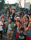 A Palestinian fires his rifle in celebration as children dance around him at Ain al-Hilweh refugee camp near the port city Sidon in south Lebanon September 11, 2001. Arab leaders voiced shock and horror at devastating attacks that leveled symbols of American power Tuesday, but a chorus of cheers rose from streets that resent U.S. backing of Israel.  (Ali Hashisho/Reuters)