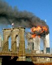 The World Trade center tower burns behind the Brooklyn Bridge September 11, 2001 in New York. In the worst attack on American soil since Pearl Harbor, three hijacked planes slammed into the Pentagon and New York's landmark World Trade Center, demolishing the two 110-story towers that symbolize U.S. financial might. (Chris Kosachuk/Reuters)