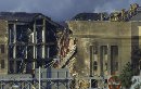 Firemen work on the roof of the Pentagon after a hijacked aircraft crashed into it, September 11, 2001. The crash caused untold casualties and massive damage that sent the nation's capital into shock and led President Bush to order extraordinary security measures. District of Columbia Mayor Anthony Williams declared a state of emergency in the city and all the hospitals in the region were put on 'maximum alert.' Most of the federal government shut down for the day.  (Kevin Lamarque/Reuters)