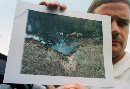 Mark Stahl of Somerset, Pennsylvania displays a photo he took early on September 11, 2001 after United Airlines Flight 93 crashed just outside of Shanskville. Stahl heard the crash and wandered up to the site where he took the photo before the area was cordoned off by rescue workers.  The plane crashed shortly after two hijacked commercial planes slammed into the twin towers of the New York's World Trade Center, causing both 110-story landmarks to collapse. (Jason Cohn/Reuters)