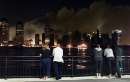 Smoke still pours from the rubble of New York's World Trade Center as Jersey City, New Jersey residents stand at the Hudson River waterfront and watch in the evening September 11, 2001. The buildings collapsed after each of the towers was hit by hijacked aircraft in one of numerous acts of terrorism directed at the United States earlier in the day.   REUTERS/Ray Stubblebine