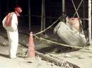 A worker looks a the tire from a jet laying in the street near the destroyed World Trade Center in New York on September 11, 2001. Two hijacked U.S. commercial planes slammed into the twin towers of the World Trade Center on Tuesday, causing both 110-story landmarks to collapse in thunderous clouds of fire and smoke.   REUTERS/Shannon Stapleton