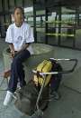 Pamela Williams of Tampa, Florida, sits outside the yellow taped doors to the terminal at Hartsfield International Airport in Atlanta, Georgia, which remained closed on September 12, 2001. Williams was on a flight from Newark, New Jersey, headed to Tampa, Florida, when they were told to get off the plane as all flights in the United States were grounded after attacks in New York City and Washington on September 11, 2001.  REUTERS/Tami Chappell