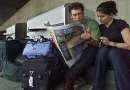 Ian Sheeler (L) of London, England and Maria Zedda of Italy read a newspaper about the U.S. attacks as they wait outside the terminal at  Hartsfield International Airport in Atlanta, Georgia, which remained closed on September 12, 2001. Sheeler and Zedda are traveling around the United States and were heading to Miami before flying back to New York. All flights in the United States were grounded after attacks in New York City and Washington D.C. on September 11, 2001.  REUTERS/Tami Chappell