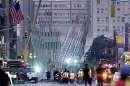 Workers walk near the wreckage of the World Trade Center in New York City  September 12, 2001. The World Trade Center towers were destroyed after being struck by commercial planes in a terrorist attack on Spetember 11.  REUTERS/Mike Segar