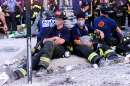 New York City firefighters take a break on West Street near the wreckage of the World Trade Center in New York City  September 12, 2001. The World Trade Center towers were destroyed after being struck by planes in a terrorist attack on September 11.  REUTERS/Mike Segar