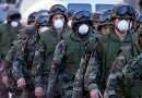 U.S. National Guard troops, wearing protective face masks, march down West Street near the wreckage of the World Trade Center in New York City  September 12, 2001. The World Trade Center towers were destroyed after being struck by planes in a terrorist attack on September 11.                               REUTERS/Mike Segar