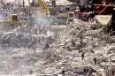 Rescuers and emergency workers comb through the smoking wreckage of the World Trade Center Towers in New York September 12, 2001 as they search for trapped survivors of the terrorist attack on the New York landmark. Two hijacked commercial airliners were deliberately crashed into the twin towers bringing them crashing to the ground September 11.   REUTERS/Jim Bourg