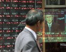 A Japanese businessman watches President George W. Bush live speech following the attacks on the World Trade Center and the Pentagon in Tokyo September 12, 2001. Tokyo stocks plunged four percent to below the 10,000 level for the first time in 17 years, jolted by the terror attacks in New York and Washington. The Tokyo Stock Exchange said it would reduce its price limits by half for the day due to the anticipated high level of volatility. (Eriko Sugita/Reuters)