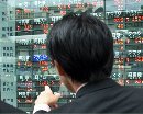 A Tokyo businessman points at stock prices lit up on a quotation board outside a brokerage September 12, 2001. Tokyo stocks plunged to below the key 10,000 level for the first time in 17 years, jolted by the terrorist attacks in New York and Washington. (Haruyoshi Yamaguchi/Reuters)