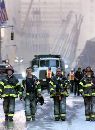 Firefighters walk up Church street and away from the remains of the World Trade Center towers in New York, early September 12, 2001. President Bush committed the United States to a 'monumental struggle of good versus evil' as emergency workers dug desperately for survivors. (Mike Segar/Reuters)