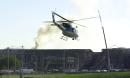 A military helicopter takes off to patrol the area around the Pentagon as firefighters continue to pour water on the roof in Washington, Wednesday Sept. 12, 2001. A hijacked airliner plowed into the structure Tuesday causing a fire which still burns. The impact collapsed part of the building to the left of the crane.  (AP Photo/Steve Helber)